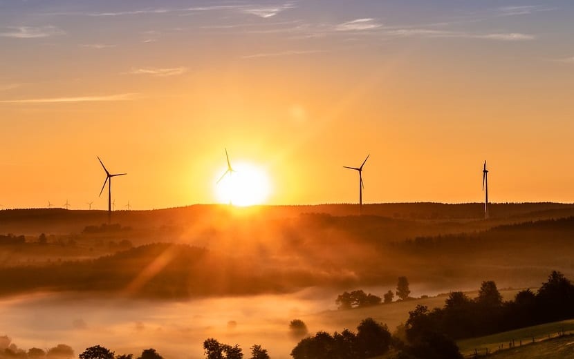 summer wind energy - sun and wind turbines in field