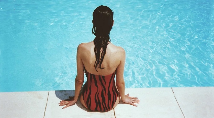 Geothermal heated swimming pool - Woman sitting with feet in water