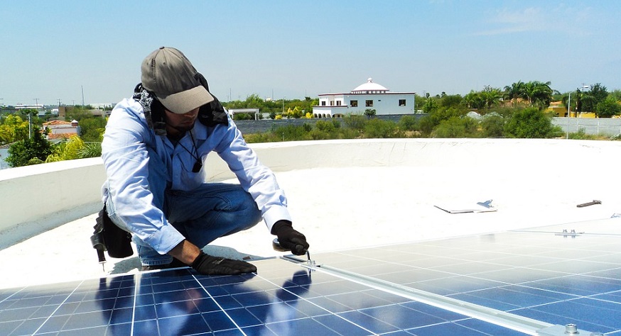 California home solar panels - man installing solar PV system on roof