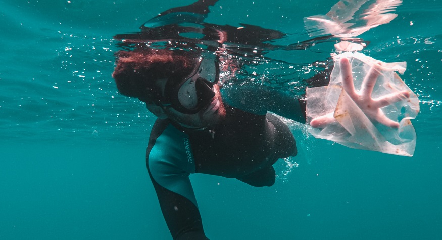 Reduce plastic pollution - diver collecting plastic pollution from water