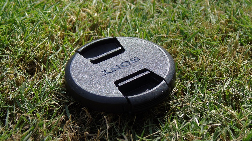 Renewable energy initiative - Sony camera lens cap on grass