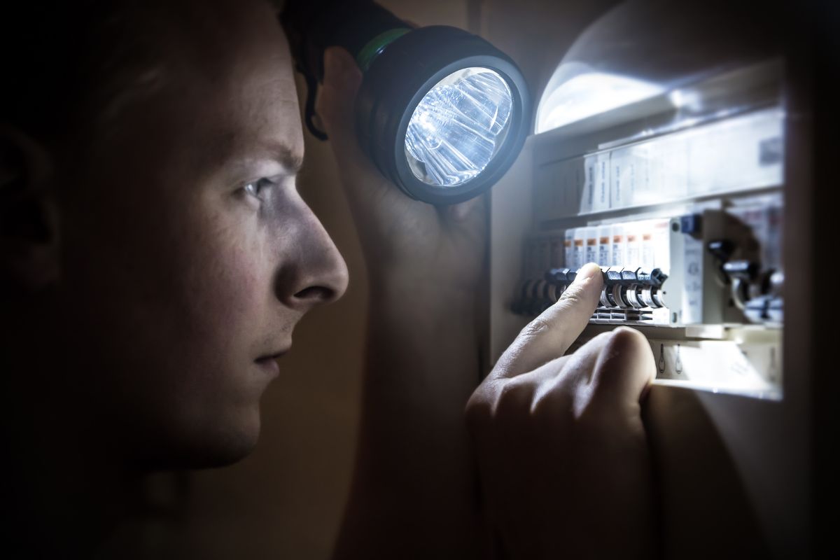 Fuel cells - person with flashlight checking circuit breaker during power outage