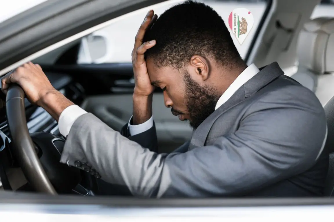 Hydrogen cars - Person looking frustrated behind wheel of car - California flag-