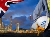 Hydrogen power - UK - Image of a Refinery - Person holding hard hat with H2 on it